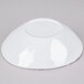 A white, irregularly shaped melamine bowl shown upside down.