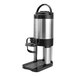 A brushed stainless steel 1-gallon thermal coffee server with a hands-free dispensing stand.