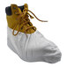 A large yellow work boot covered by a white disposable microporous shoe cover.