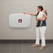 A gray horizontal surface-mounted baby changing station attached to a tiled wall.