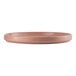 A round, coral-colored porcelain plate with a stackable design.