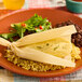 A green chile and cheese tamale served on a plate with rice, black beans, and a side salad.