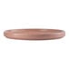 A round, coral-colored porcelain plate with a slightly raised edge.