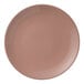A round, coral-colored porcelain coupe plate.