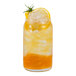 A glass of iced lemon-lime soda with bursting boba, garnished with a lemon slice and herbs.