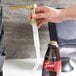 A gold and white Torani flavoring sauce pump designed for 64 fl. oz. bottles.