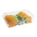 A clear plastic container filled with fresh squash blossom edible flowers.