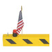 A yellow overhead door guard with black diagonal stripes, an American flag, and a red blinking light.