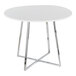 A round white dining table with a chrome metal base.