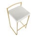 A gold steel barstool with a low back and a white faux leather seat.
