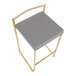 A counter height stool with a gold steel frame and a gray faux leather seat.