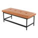 A rectangular bench with camel-colored faux leather upholstery and a black metal frame.
