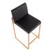 A counter height stool with a gold steel frame and a black faux leather seat and back.