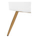 A close-up of a white faux leather bench with a gold steel leg.