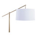 A gold metal floor lamp with an off-white linen drum shade.