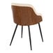 A modern arm chair with a walnut wood back, cream faux leather trim, and black metal legs.