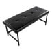 A black faux leather bench with a tufted seat and a black metal frame.