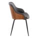 A modern armchair with a walnut wood back, brown faux leather upholstery, and black metal legs.