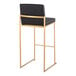 A high back barstool with a gold steel frame and black faux leather back and seat.