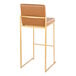 A modern barstool with a gold metal frame and camel faux leather back and seat.
