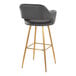 A barstool with a gray faux leather bucket seat, armrests, and gold metal legs.