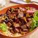 A bowl of Offbeast Premium Plant-Based Steak Bites served with rice, black beans, lettuce, jalapeños, and pickled onions.
