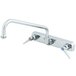 A chrome T&S wall mount faucet with two handles and a swing nozzle.