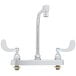 A chrome T&S deck-mount faucet with two handles on a white surface.