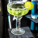A Libbey Yucatan margarita glass with a margarita and a lime slice on the rim.
