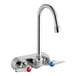 A chrome T&amp;S wall mount workboard faucet with two blue and red knob handles.