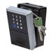 A wall-mounted ABUS KEYGARAGE One 787 smart key storage lockbox with a keypad and a set of keys attached.