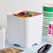 A square white melamine jar filled with colorful candy.