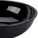 A black round ribbed plastic bowl.