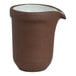 A small brown stoneware sauce pourer or creamer with a spout and a white speckled interior.