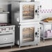 A double-stacked set of half size electric combi ovens with manual controls, designed for commercial kitchen use.