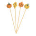 A set of four bamboo food or cocktail picks with fall leaf and pumpkin decorations on top.