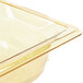 A Vollrath amber plastic food pan on a counter.