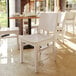A white solid wood dining chair with a simple, modern design.