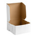 A white, square, cardboard bakery box with an open lid and brown interior.