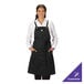 A black customizable poly/cotton cross-back bib apron with three pockets, shown worn over a white shirt.