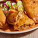 A plate of beef picadillo empanadas with a flour shell, served with a side of mixed vegetables.