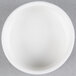 A small, round, white porcelain salt and pepper dish.