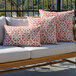 A set of rectangular lumbar pillows with a rusty orange and white circular pattern, displayed on an outdoor sofa.