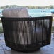 A black rope and teak swivel chair with light-colored Sunbrella cushions designed for outdoor use.