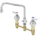 A chrome deck-mount faucet with two lever handles and an 8" swing nozzle.
