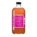 A glass bottle of Stirrings Mai Tai Mix with an orange liquid and a pink label.