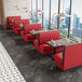 A bright red upholstered double booth with a button-tufted back and walnut finishes, designed for restaurant seating.