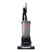 A cordless upright vacuum cleaner with a gray and black design, featuring a handle, hose, and cleaning head.