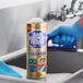 A 21 oz. container of Bar Keepers Friend all-purpose cleaning powder placed on a stainless steel sink.