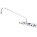A T&S chrome wall mount faucet with lever handles and a swing spout.